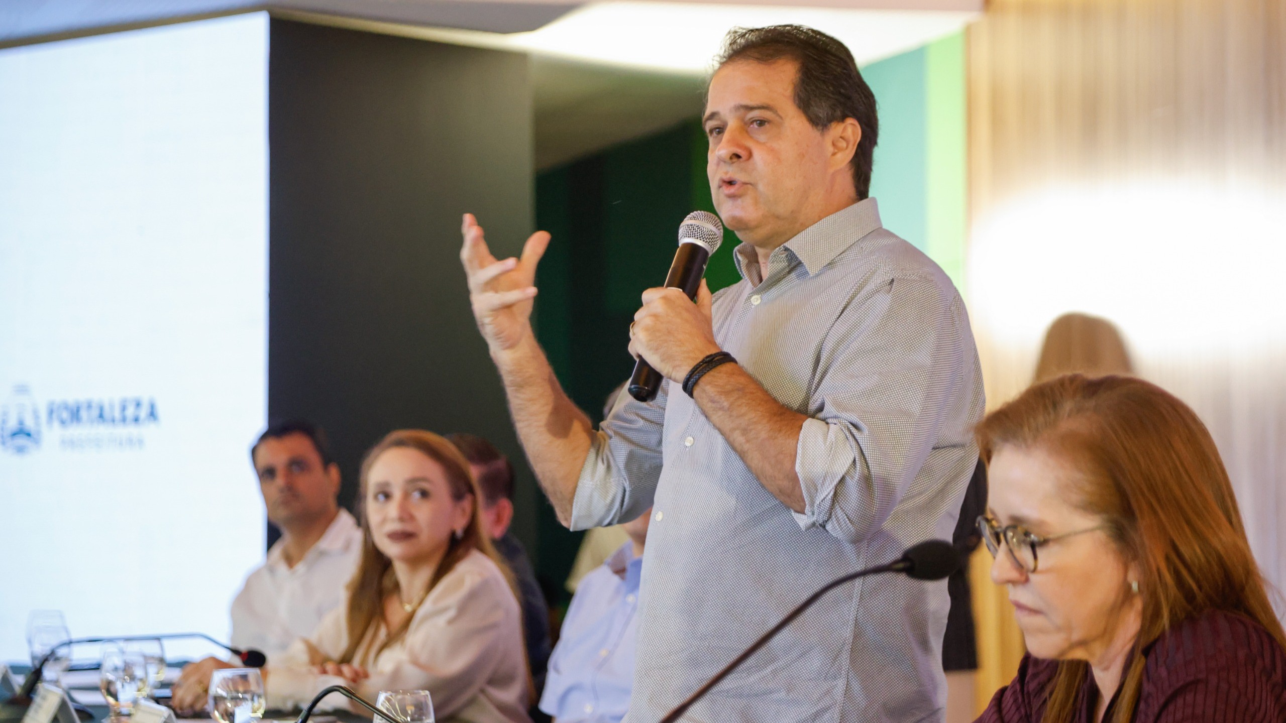 prefeito falando ao microfone no auditório do paço municipal